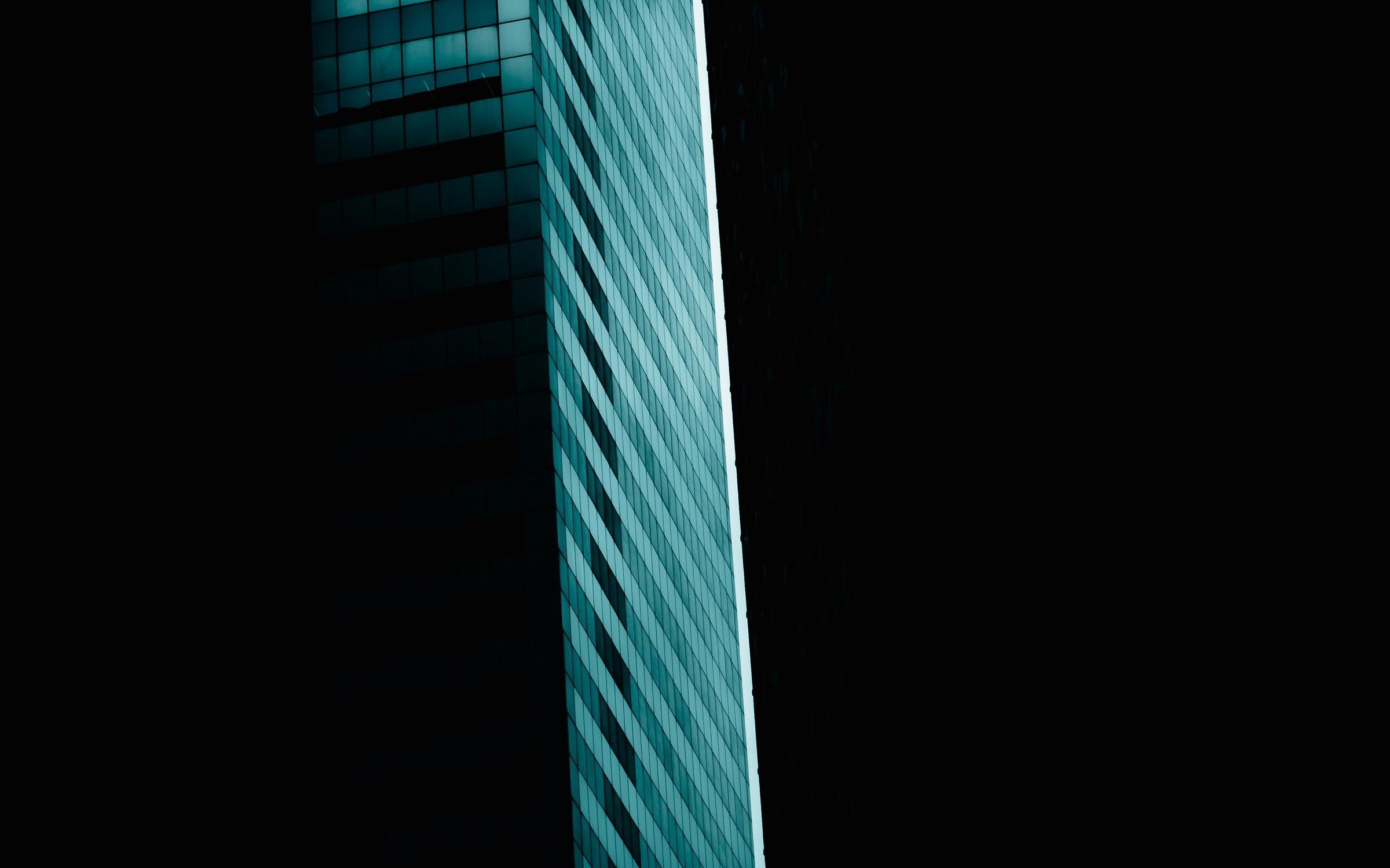 An ordered glass facade glowing in cool blue light