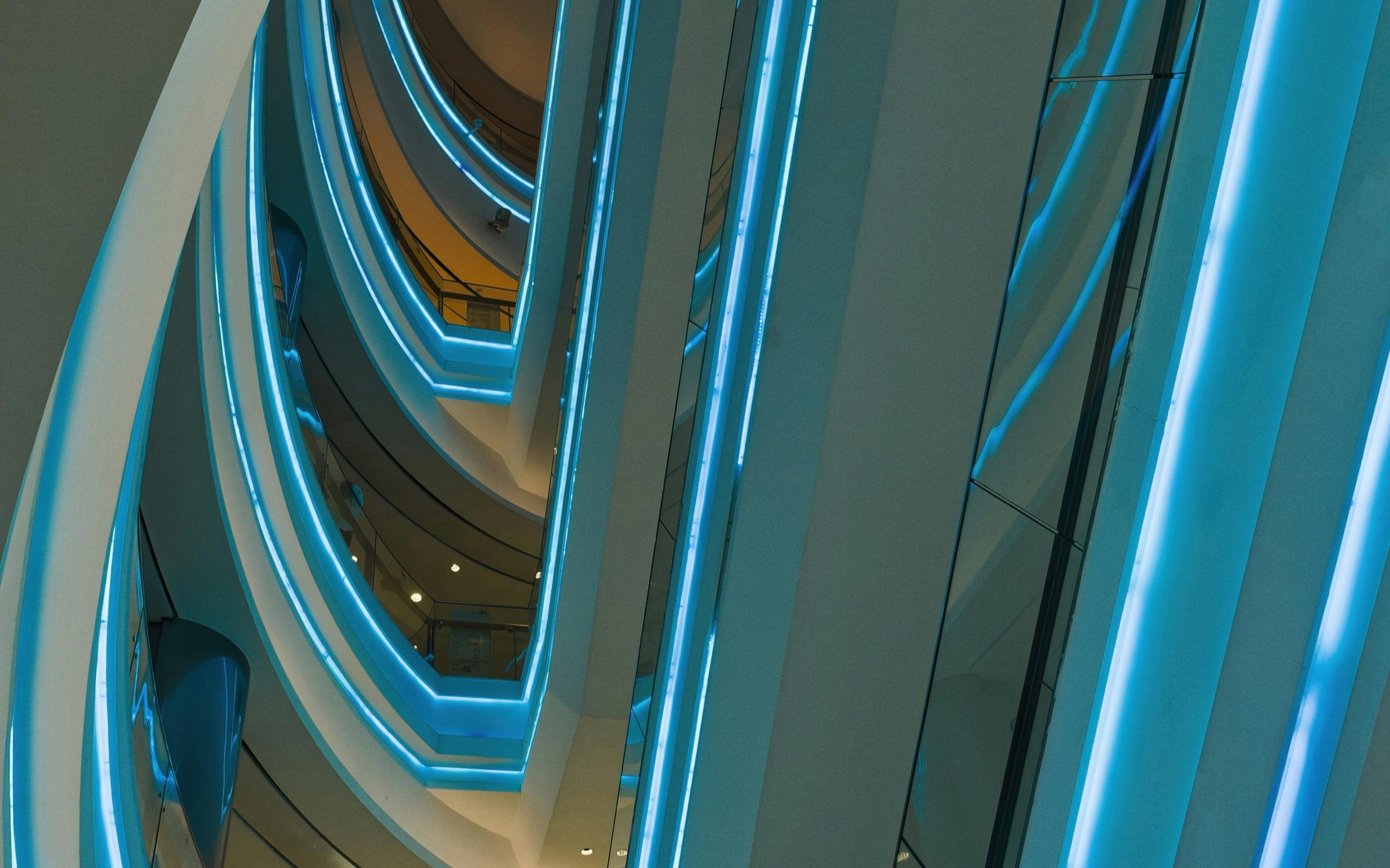 Sweeping architectural levels traced with electric-blue light